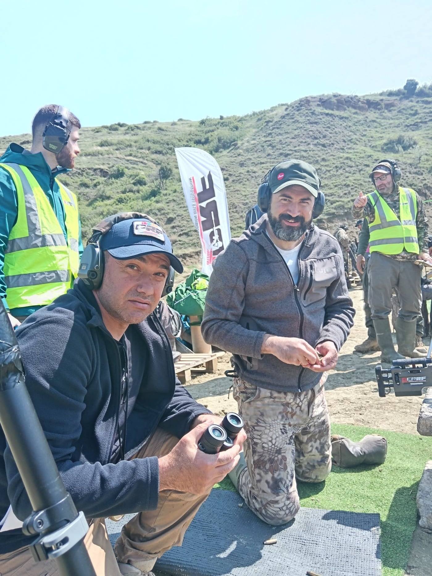 Competitors beside the firing line, a GEPRF banner behind them