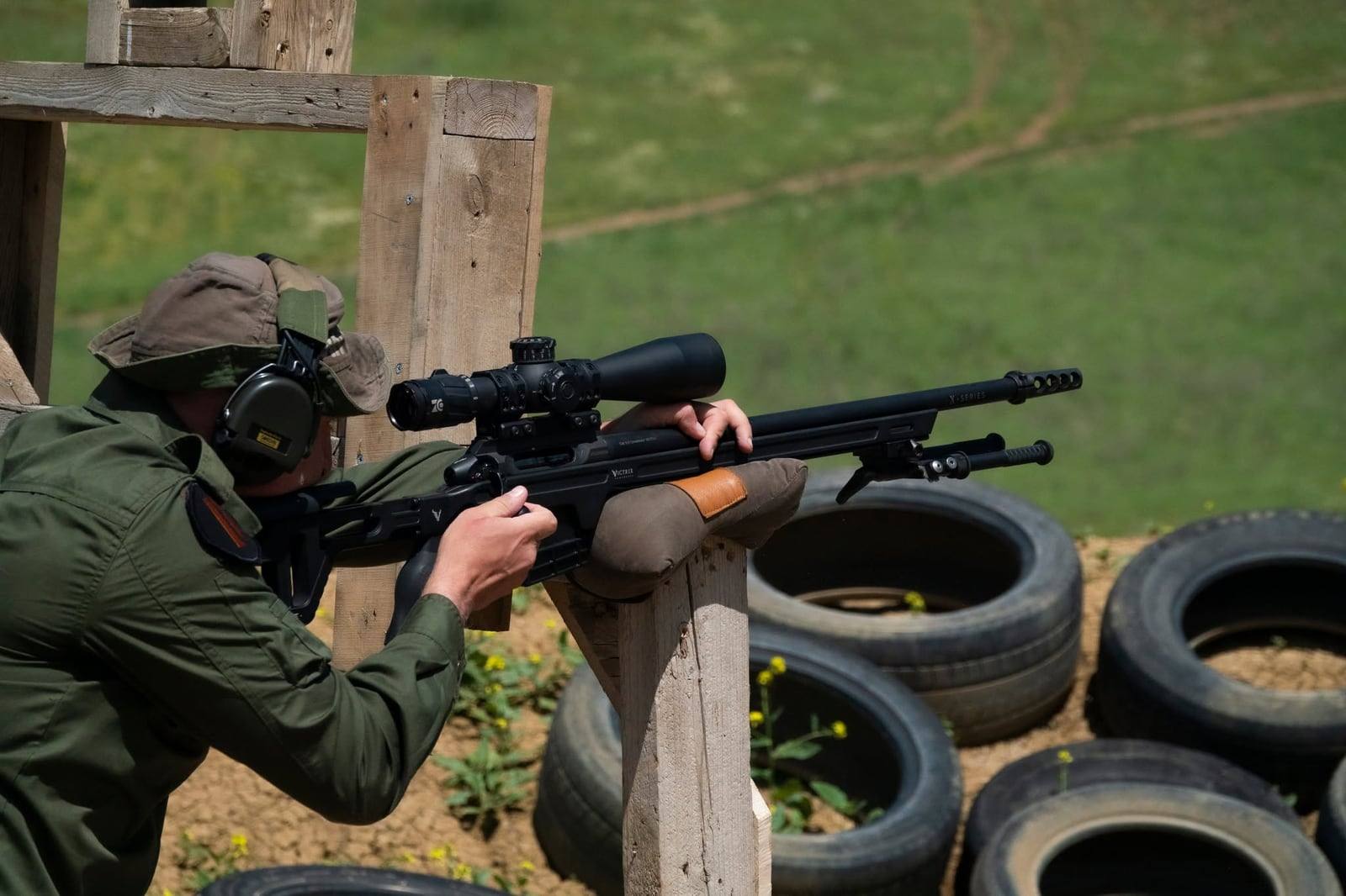 A shooter firing a Victrix off a wooden barricade