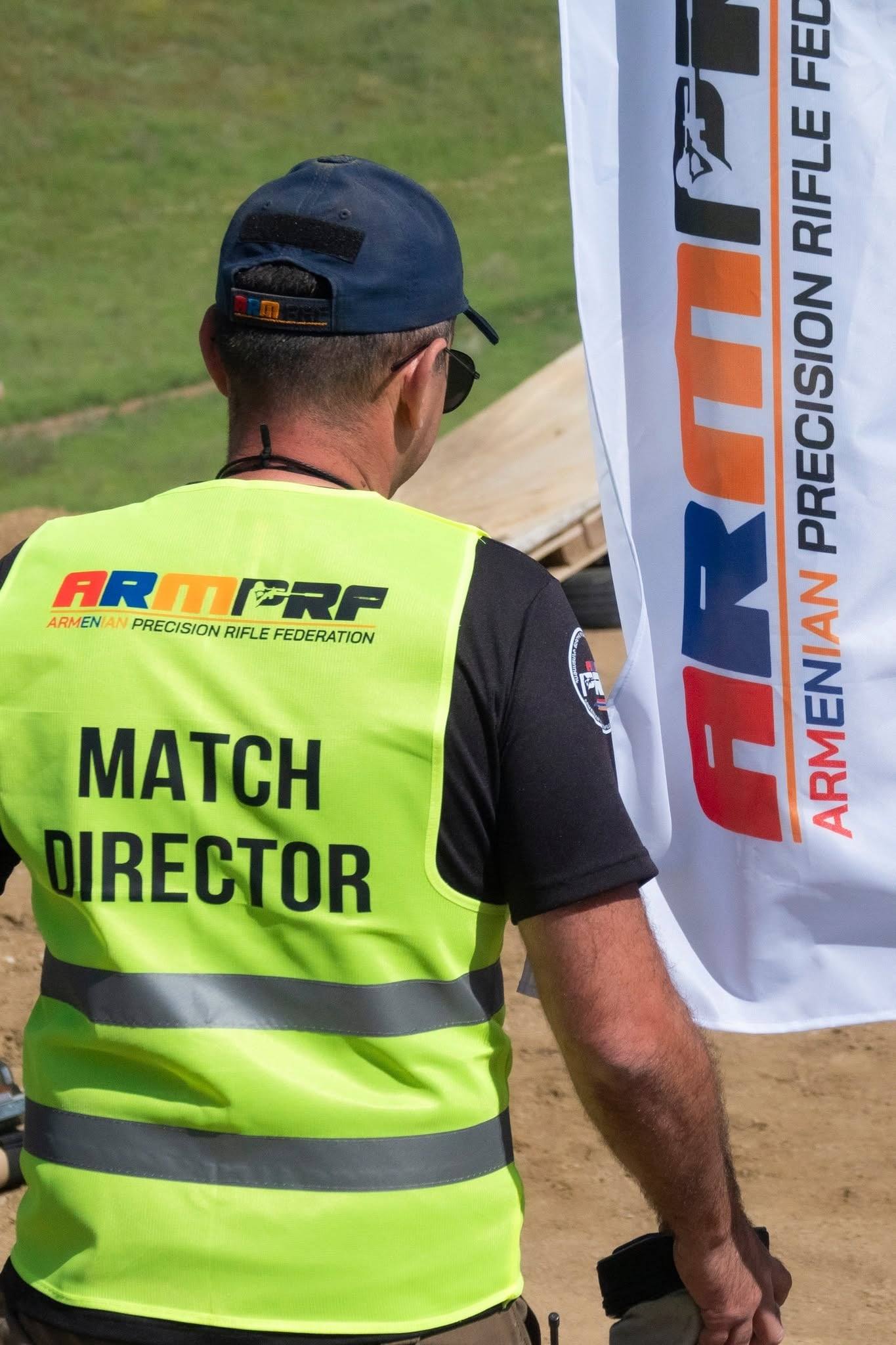 The match director beside the ARMPRF banner
