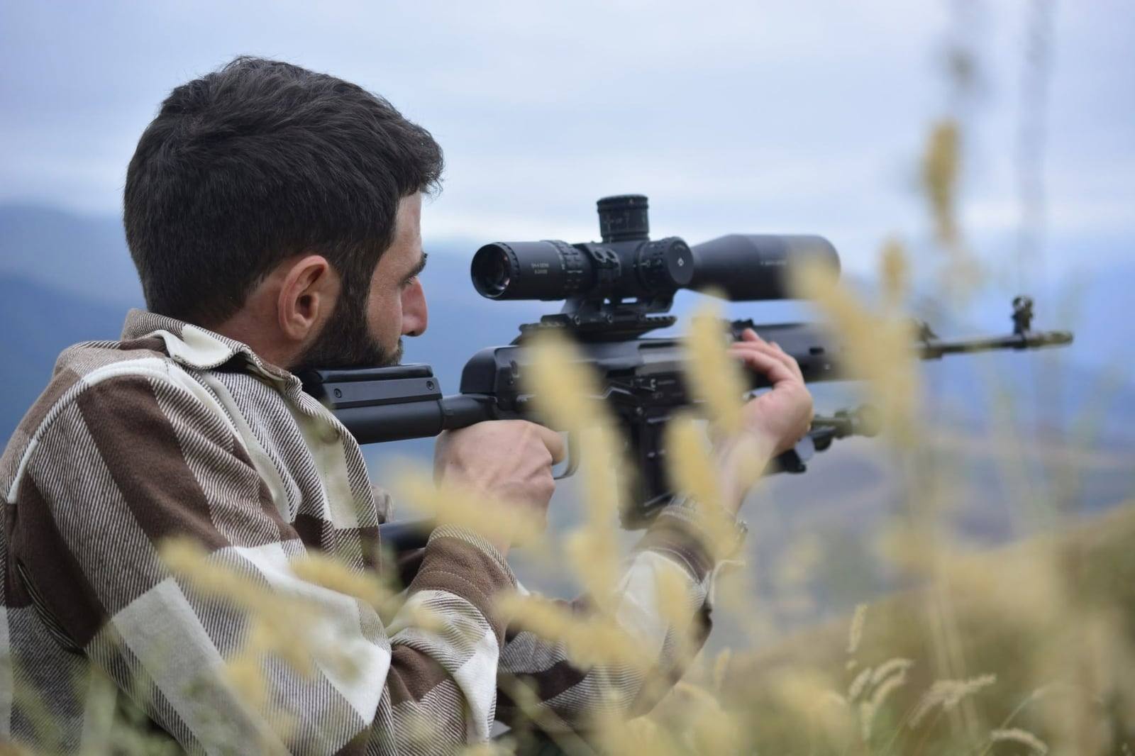 A shooter firing a self-loading rifle from a field position