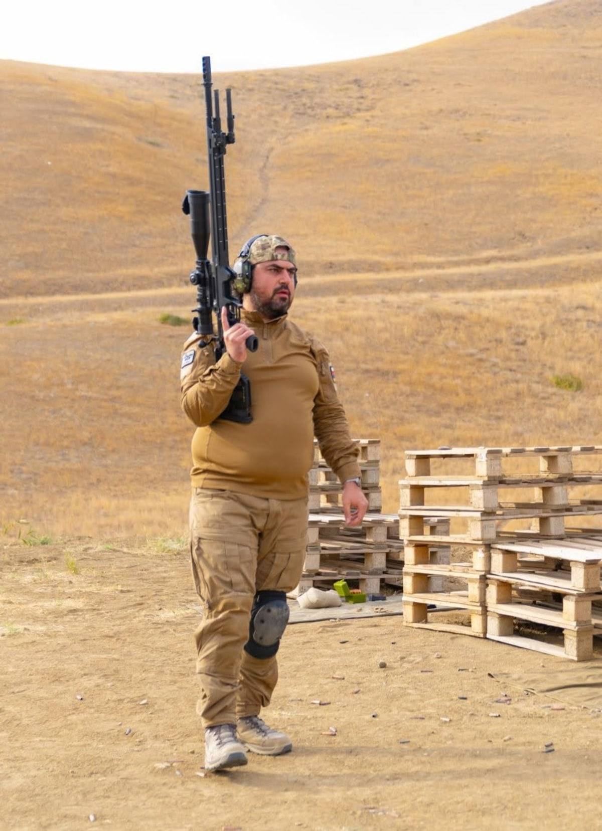 Ara Peryan beside the firing line, rifle in hand